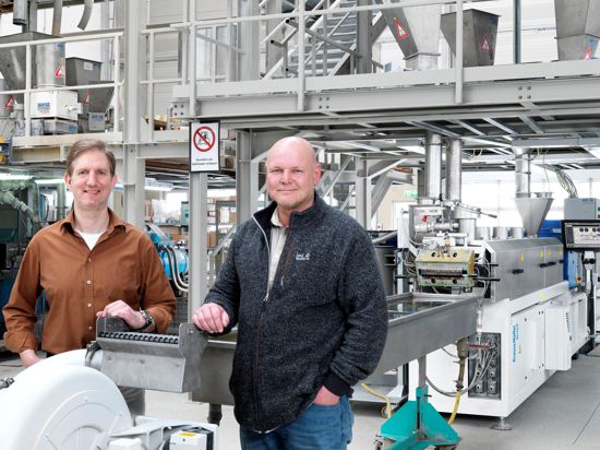 Die Geschäftsführer der Tecnaro GmbH, Helmut Nägele (links) und Jürgen Pfitzer, haben es sich zum Ziel gesetzt, Plastik zu ersetzen. Hier stehen sie vor ihrer Produktionsstraße in Ilsfeld bei Heilbronn. Aus ihren Biopolymeren werden Urnen, Spielzeug, Schneeketten oder Kopfhörer und vieles mehr.