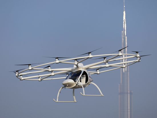  Ein batteriebetriebener Zweisitz-Prototyp der deutschen Firma Volocopter fliegt am 26.09.2017 über Dubai (Vereinigte Arabische Emirate). Im Hintergrund erkennt man den Burj Khalifa (r). 