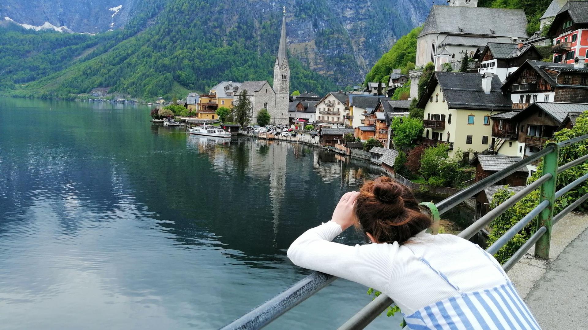 Eine Touristin fotografiert den Hallstätter See in Österreich. Hier scheint die Welt selbst im Corona-Sommer in der üblichen Ordnung zu sein.