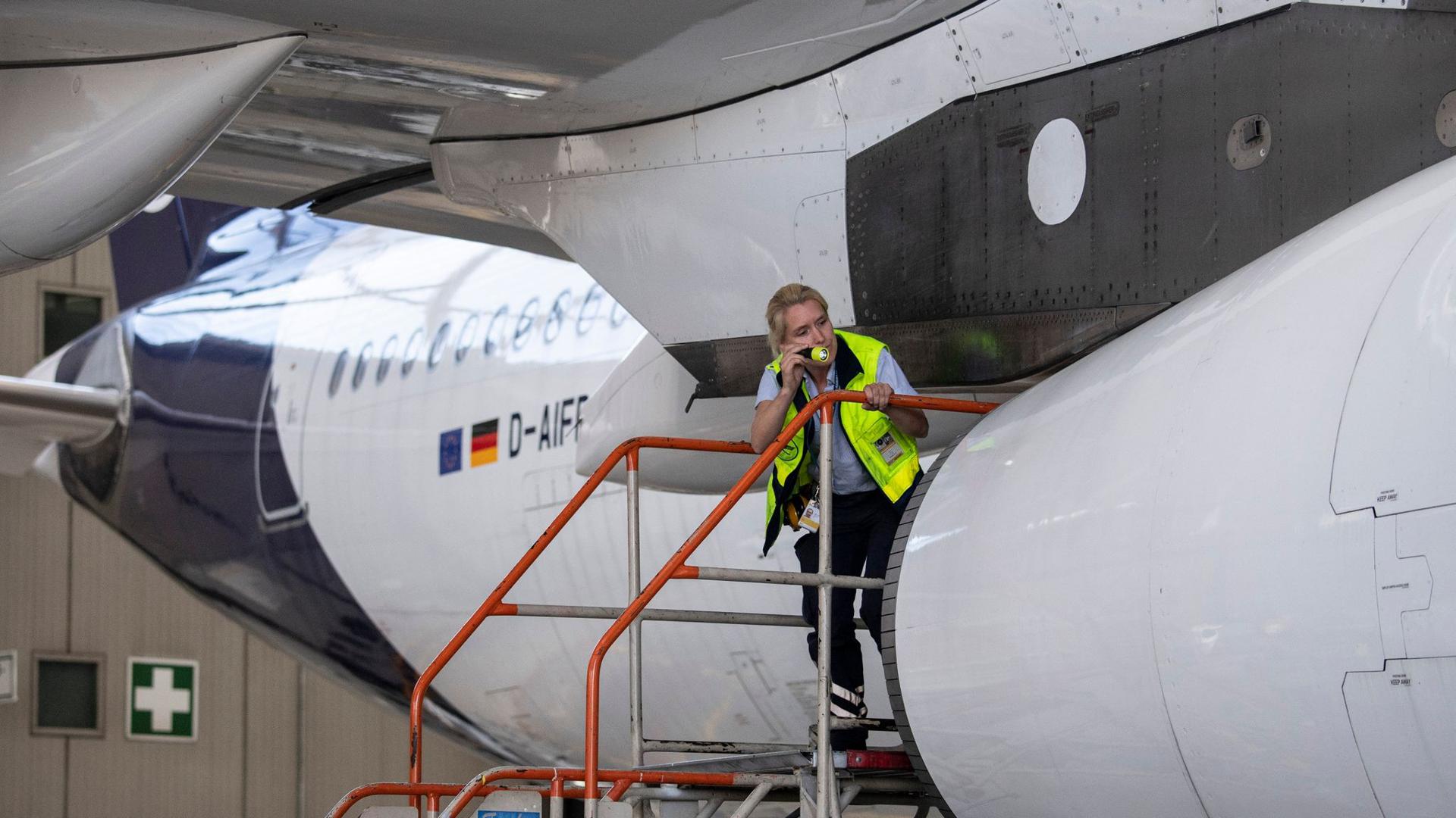Eine Technikerin der Lufthansa inspiziert das Äußere einer Passagiermaschine der Lufthansa im Hangar der Airline auf dem Flughafen Frankfurt.