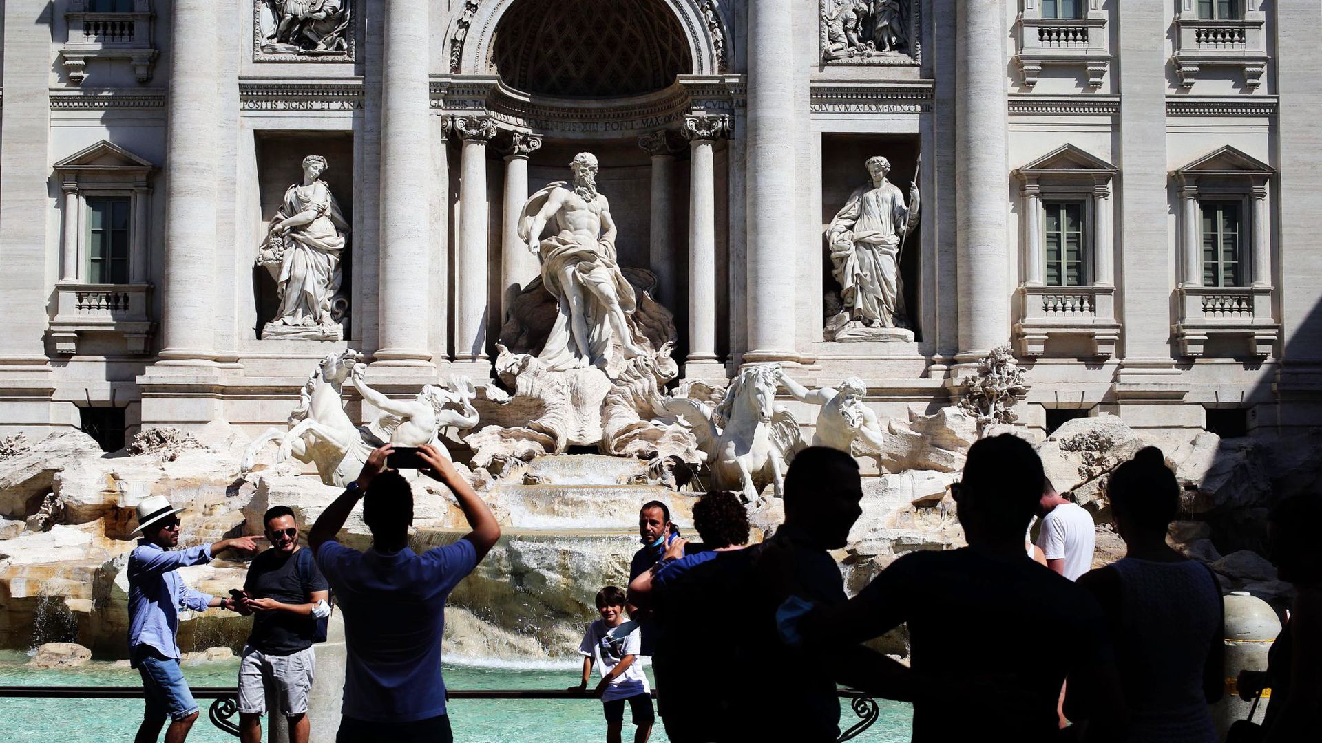 Touristen fotografieren den Trevi-Brunnen in Rom. Angesichts steigender Infektionszahlen wappnen sich manche Länder mit neuen Regeln.