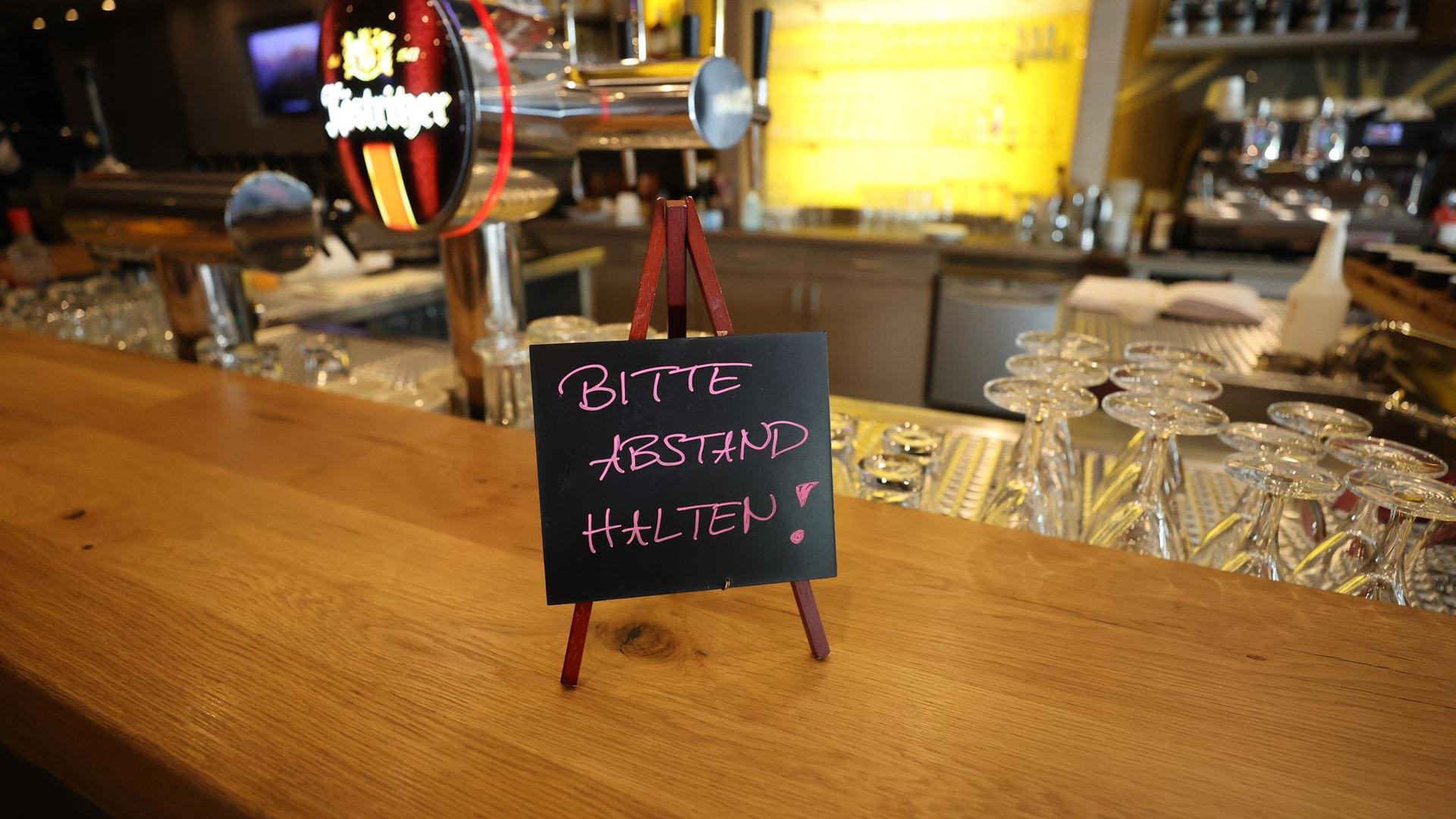 Ein Schild mit der Aufschrift „Bitte Abstand halten“ steht auf dem Tresen im Köstritzer Bierhaus.