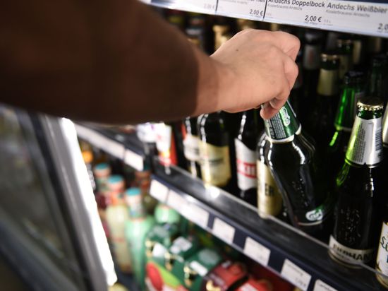 Ein Mann holt eine Flasche Bier aus einem Kühlschrank in einem Spätkauf in Berlin-Mitte.