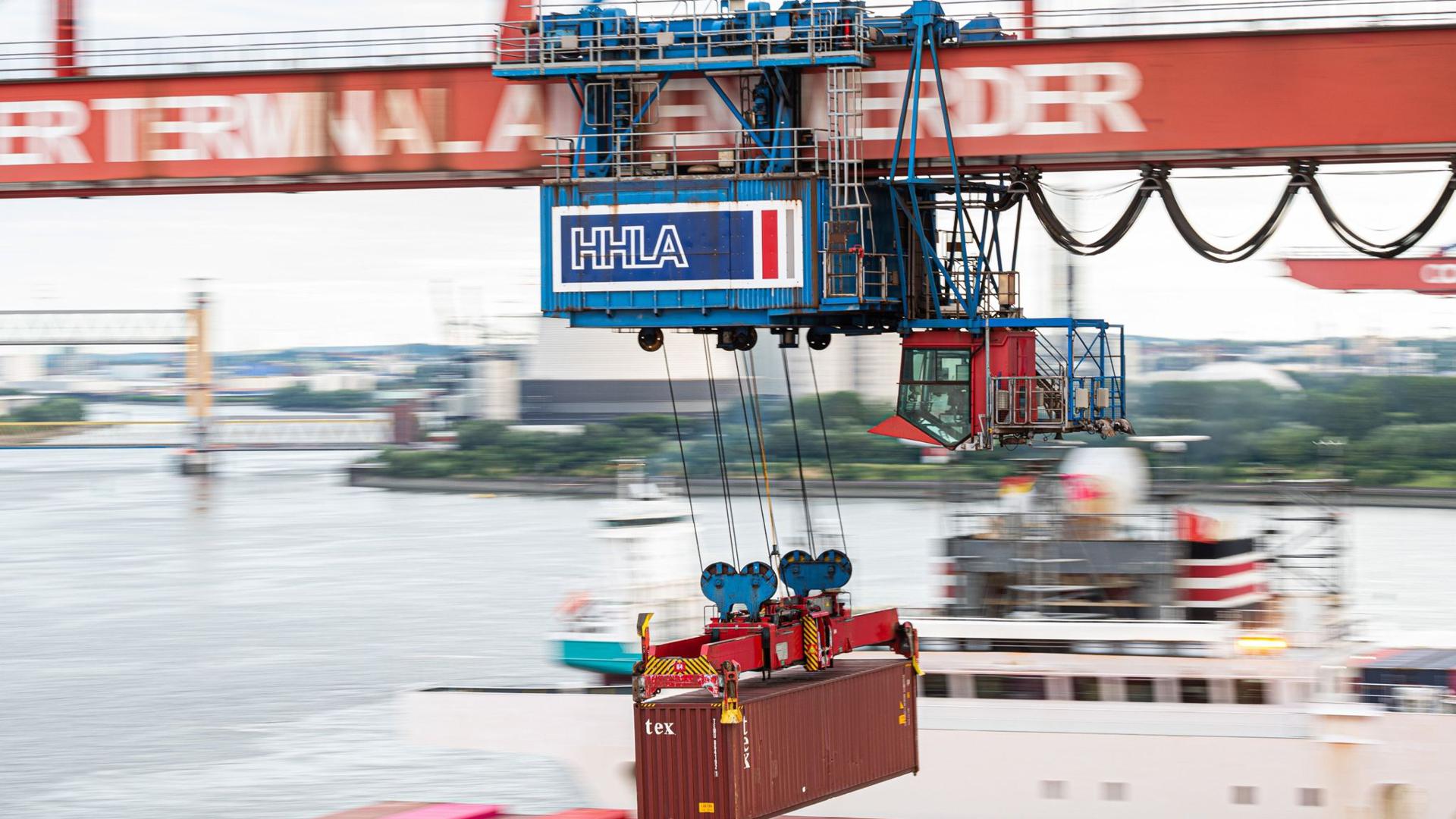 Ein Container wird auf dem Container Terminal Altenwerder im Hamburger Hafen mit einer Containerbrücke auf ein Schiff geladen. Nur in kleinen Schritten kommt Deutschlands Exportwirtschaft aus dem Corona-Tief.
