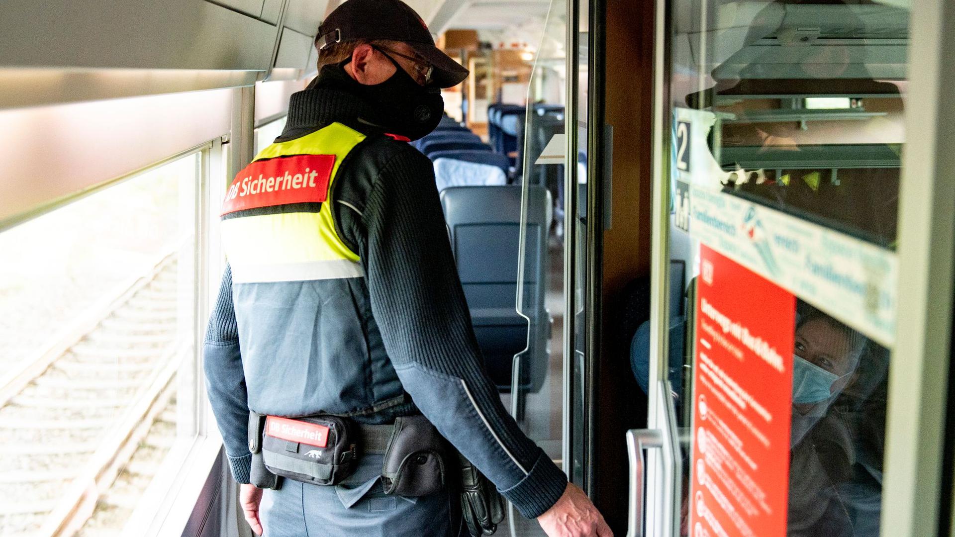 Ein Mitarbeiter der DB-Sicherheit kontrolliert in einem ICE, ob die Fahrgäste einen Mund-Nasen-Schutz tragen.