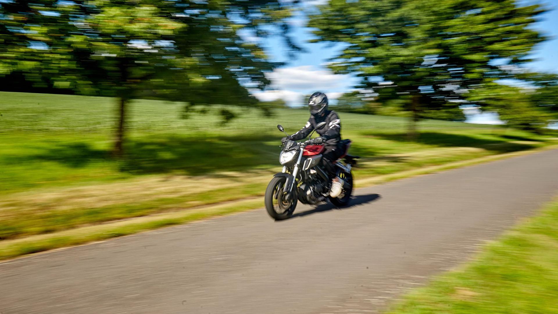Ein Motorradfahrer fährt mit einem Leichtkraftrad mit 125ccm über eine Landstraße im Westerwald.