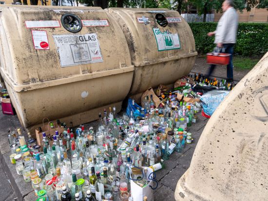 Hunderte Glasflaschen stehen neben vollen Containern am Strassenrand im Stadtteil Haidhausen in München.