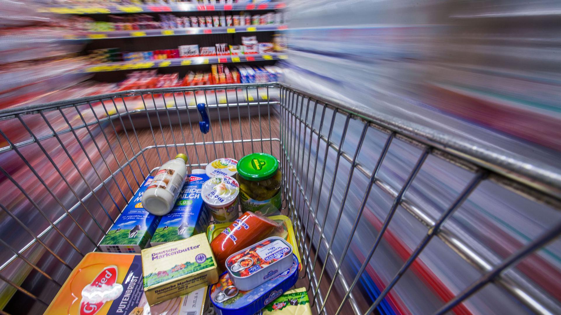 Lebensmittel liegen in einem Markt in einen Einkaufswagen. Die Corona-Krise hat den Anstieg der Verbraucherpreise 2020 stark gebremst.