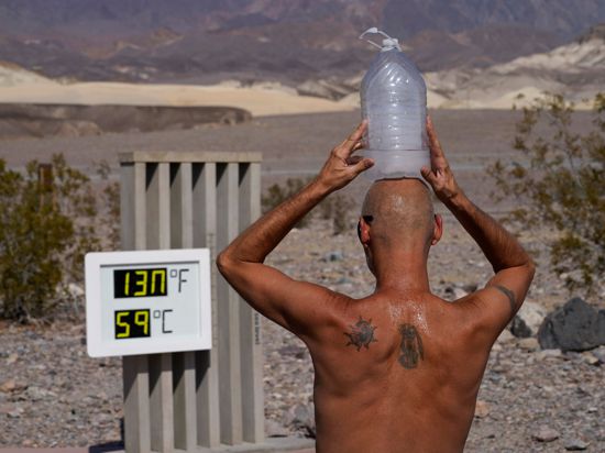 Ganz schön heiß: Ein Mann kühlt sich im „Death Valley“-Nationalpark im US-Bundesstaat Arizona bei 59 Grad Hitze mit einer mit Eiswasser gefüllten Plastikflasche auf dem Kopf ab (Archiv).