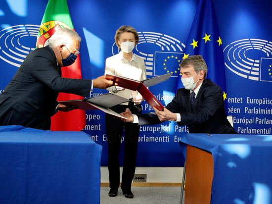 EU-Kommissionspräsidentin Ursula von der Leyen (M), schaut dabei zu, wie Portugals Premierminister Antonio Costa und EU-Parlaments-Präsident David Sassoli den Corona-Wiederaufbauplan unterzeichnen.