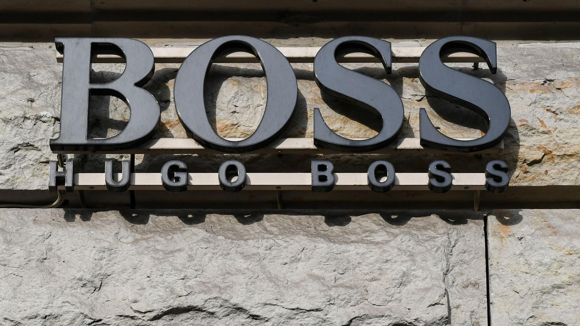 Der Schriftzug vom Mode-und Bekleidungshaus Hugo Boss ist an einem Gebäude zu sehen.
