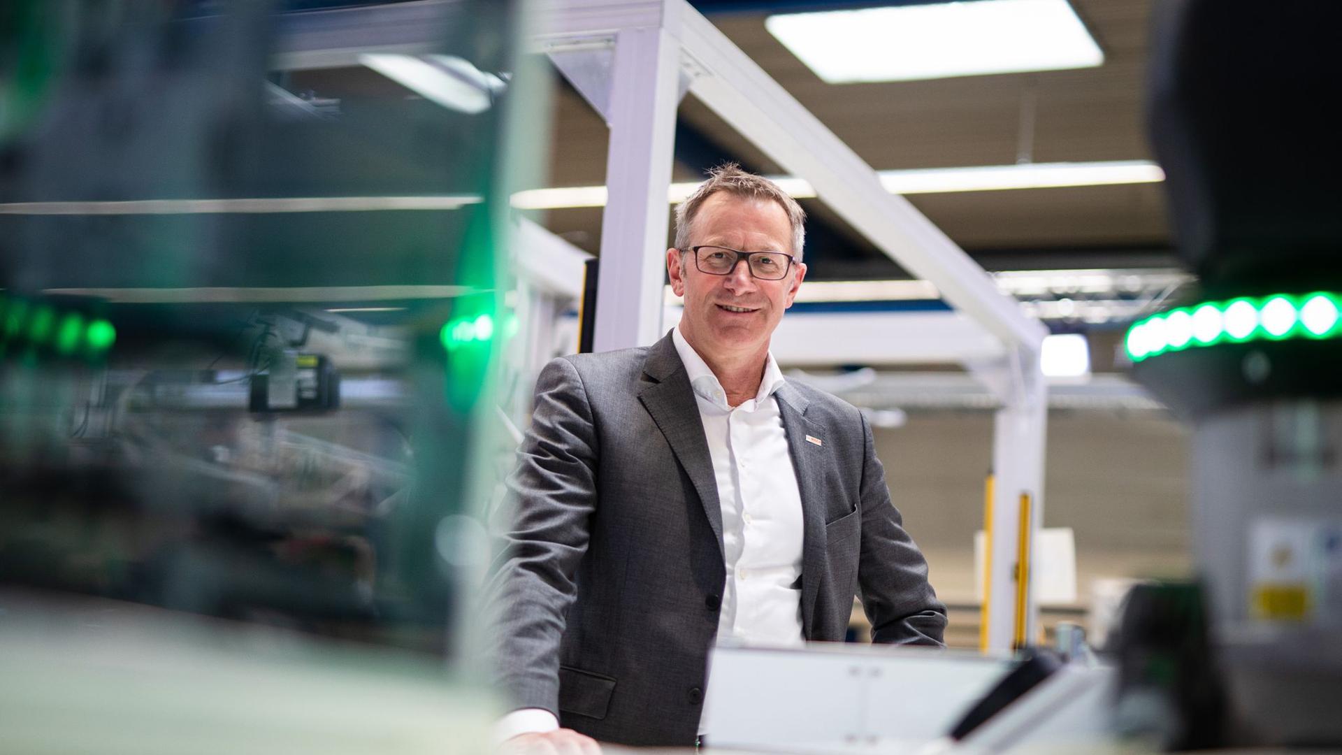 Rolf Najork steht neben einem modularen Bosch Fertigungssystem.