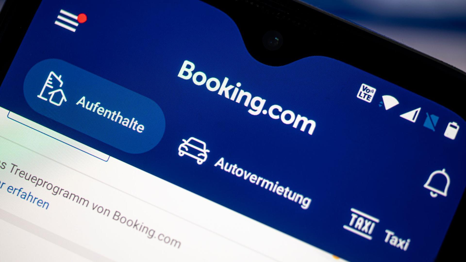 Auf einem Smartphone ist die App des Reiseportals Booking.com zu sehen.