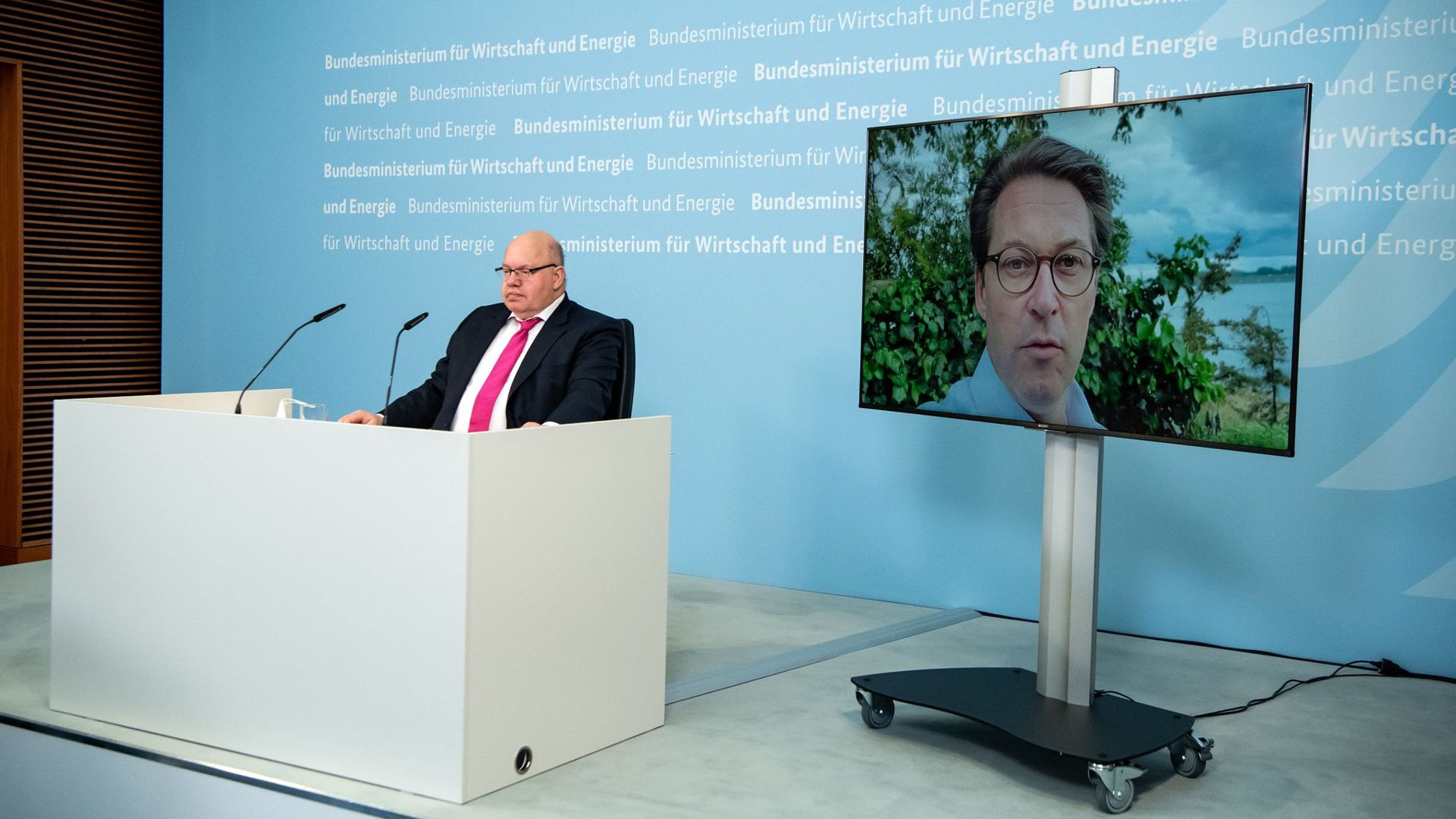 Bundeswirtschaftsminister Peter Altmaier (l) und (zugeschaltet) Bundesverkehrsminister Andreas Scheuer bei der virtuellen Pressekonferenz zur Projektauswahl für das große EU-Wasserstoffprojekt.