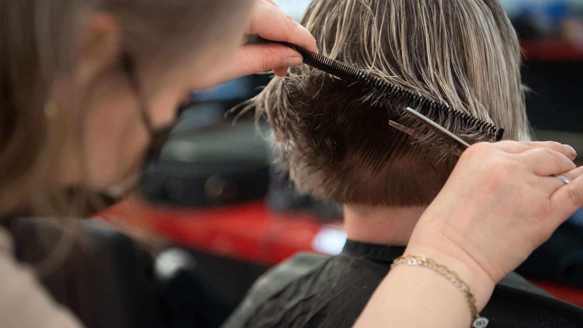Eine Friseurin schneidet einer Kundin die Haare in einem Friseursalon.