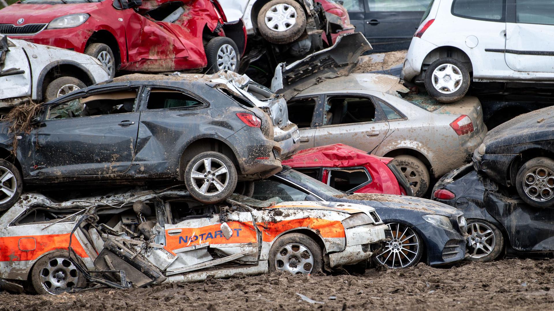 Beim Unwetter zerstörte Autos sind in Bad Neuenahr-Ahrweiler auf einem provisorischen Schrottplatz gestapelt.