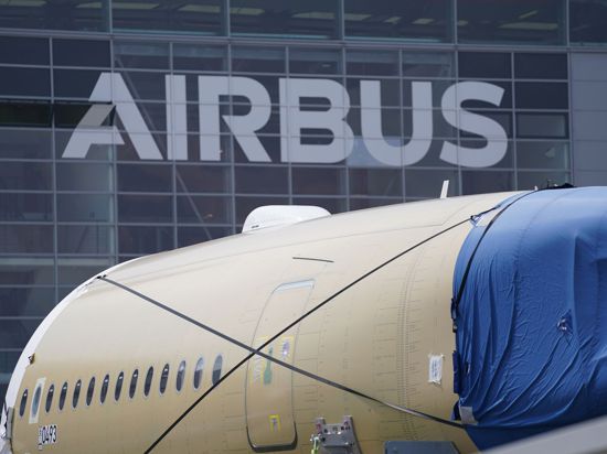 Ein Segment des Flugzeugrumpfes eines Airbus A350 steht vor einer Fertigungshalle auf dem Werksgelände des Flugzeugbauers in Hamburg.