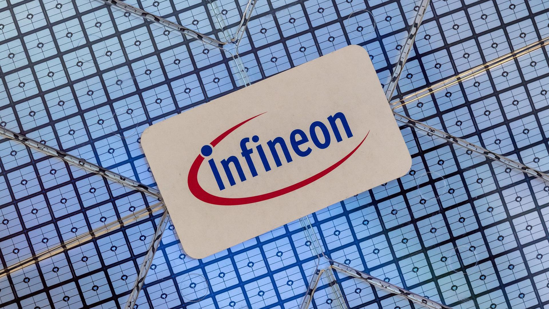 Ein Schild mit dem Logo des Halbleiter-Spezialisten Infineon klebt im Showroom des Unternehmens auf einem Wafer.