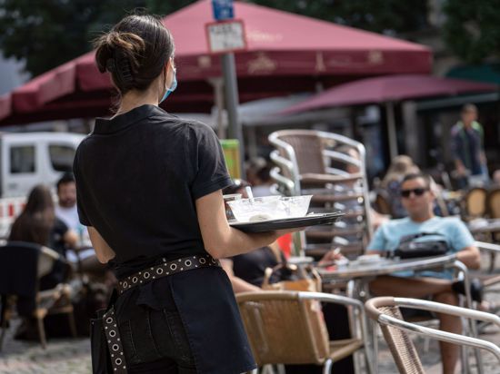 Eine Studentin (l.) bedient in einem Frankfurter Café.