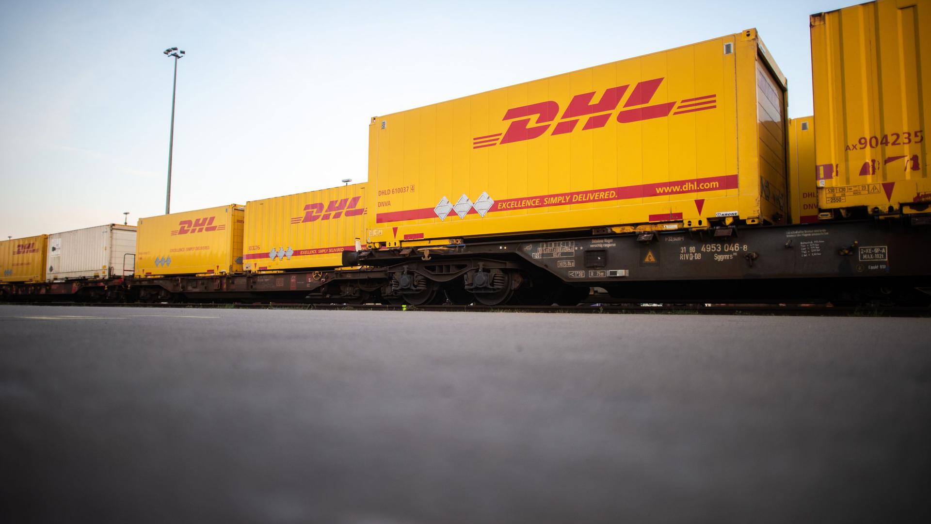 DHL-Container stehen im Güterterminal in Langerfeld auf Waggons.