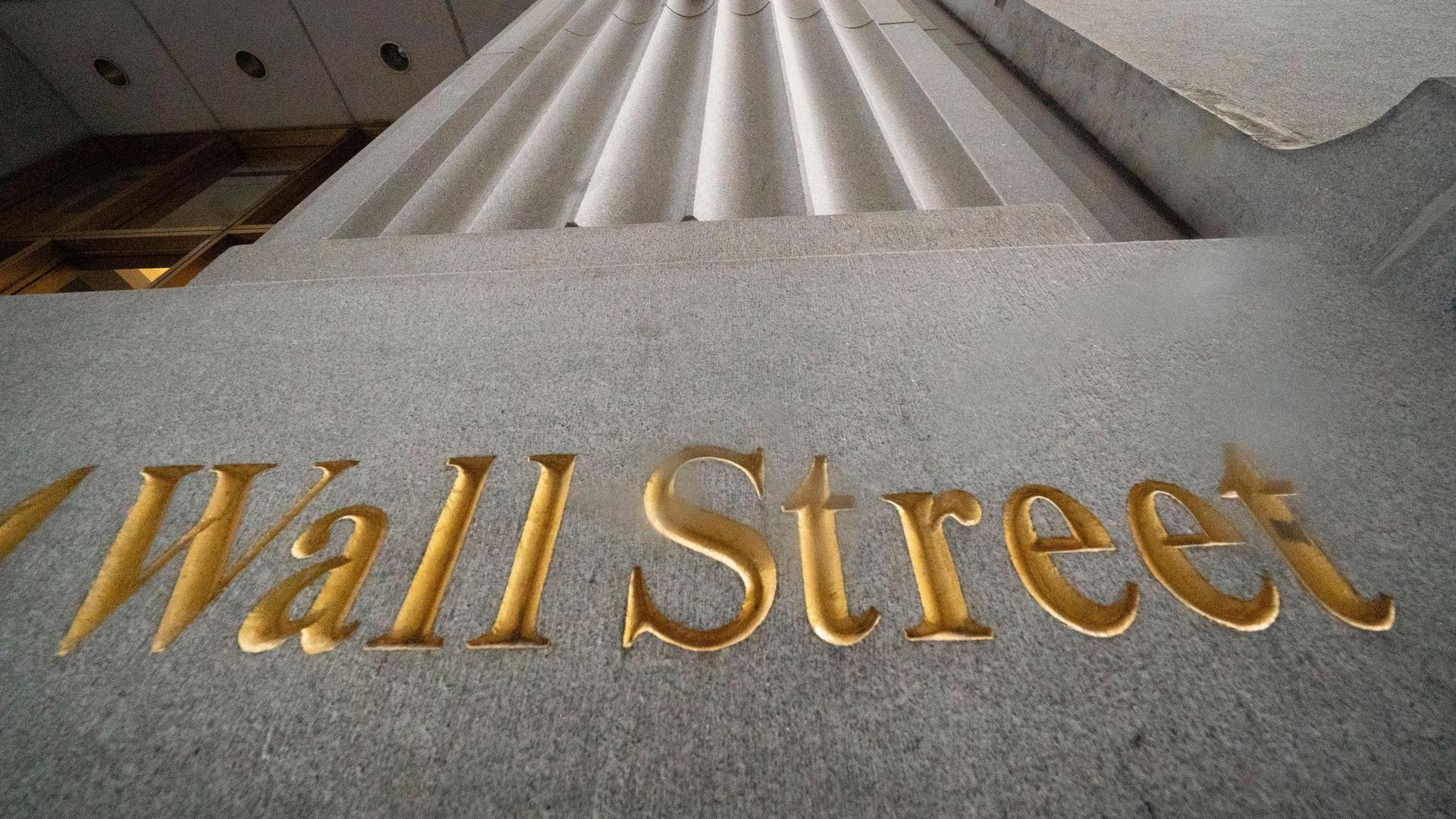 „Wall Street“ steht geritzt an der Fassade eines Gebäudes.