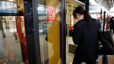 Rote Schilder weisen auf der S-Bahn Tür auf die Pflicht zum Tragen einer Maske hin.