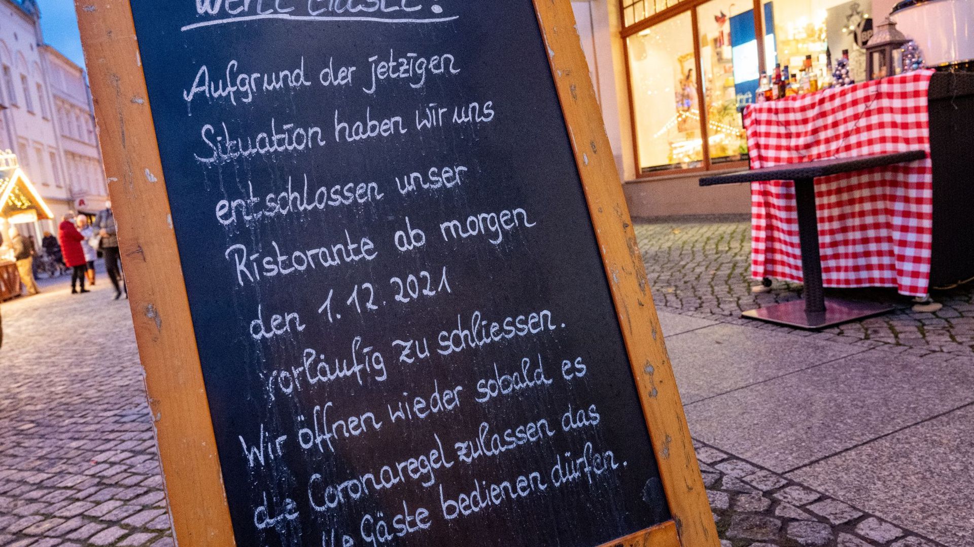 Ein Schild zur Schließung am Eingang zu einem Restaurant am Markt in Greifswald.