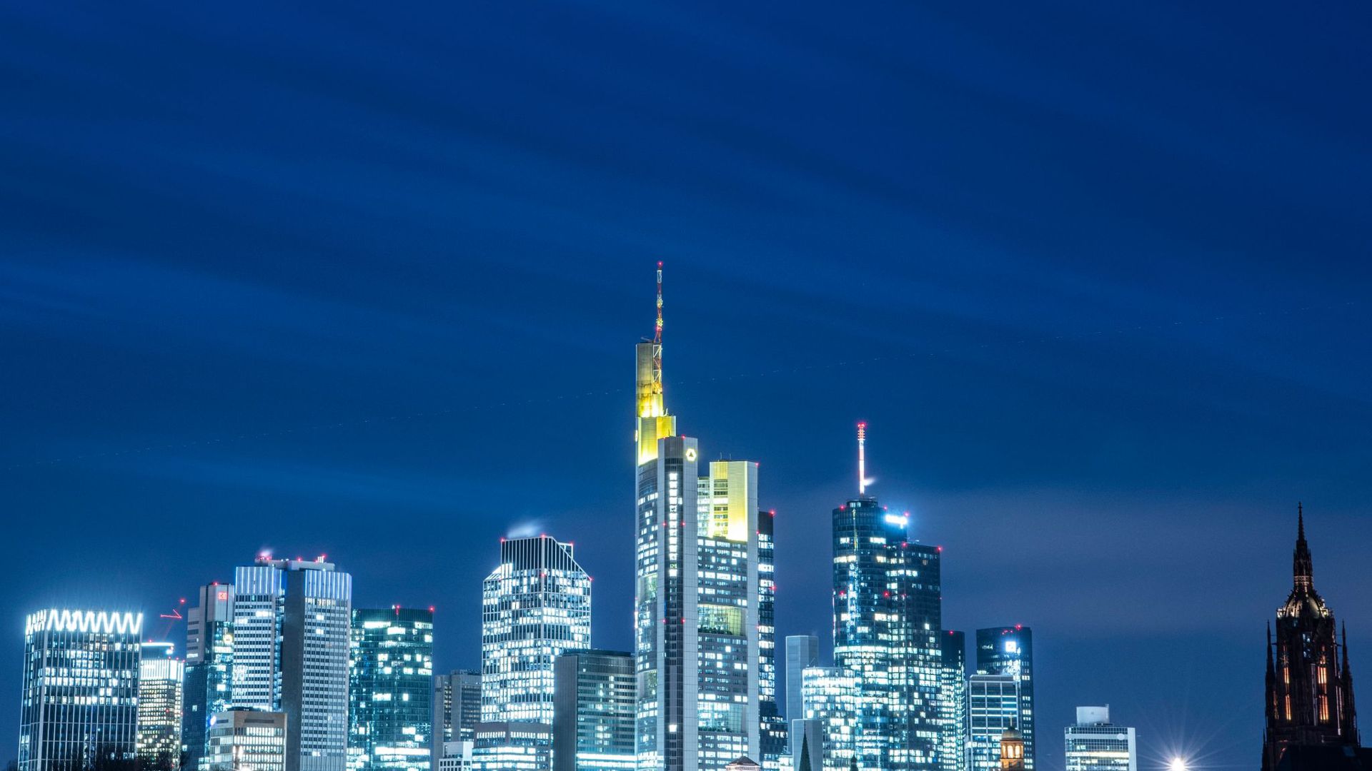 Die Lichter in den Büros der Frankfurter Bankentürme leuchten im letzten Licht des Tages.