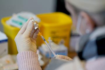Eine Mitarbeiterin eines mobilen Impfteams bereitet eine Impfspritze vor.