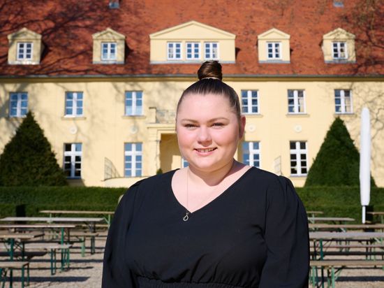 Salina Worm, Geschäftsführerin Schloss Diedersdorf, steht vor dem Schloss ihres Vaters. Dieser hat das Land Brandenburg wegen ungenügender Entschädigung während der Corona-Schließungen verklagt.