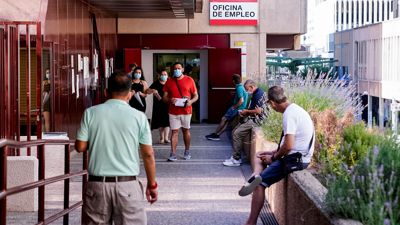 Menschen stehen vor einem Arbeitsamt in Madrid.