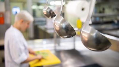 Eine Auszubildende zur Köchin arbeitet in einem Hotel in der Restaurantküche.