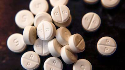 5-mg-Pillen eines Schmerzmittels mit Oxycodon auf einem Tisch. Die großen US-Apothekenketten CVS und Walgreens haben im Rechtsstreit um eine angebliche Mitschuld an der Schmerzmittel-Krise im Land einem teuren Vergleich zugestimmt.
