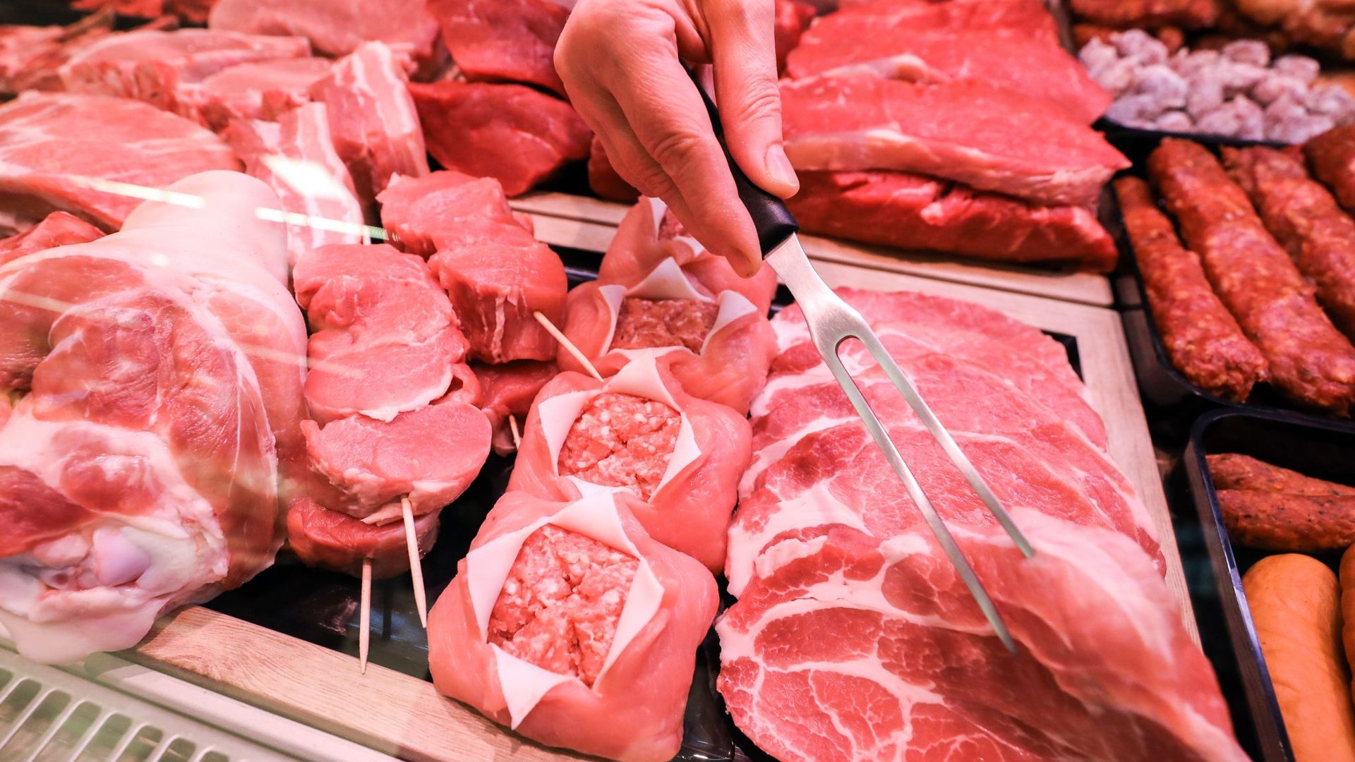 Verschiedene Sorten Schweinefleisch und Rindfleisch liegen in einer Fleischtheke in einem Supermarkt.
