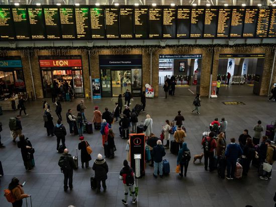 Menschen stehen an Anzeigetafeln im Londoner Bahnhof Kings Cross: Streiks behindern den Reiseverkehr zu Weihnachten erheblich.