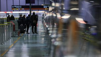 Reisende stehen am Flughafen Köln/Bonn vor einem Schalter.