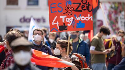 Eine Demonstrantin fordert bei einer DGB-Kundgebung zum 1. Mai in Erfurt die Vier-Tage-Woche.