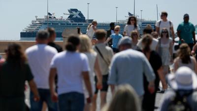 Touristen eines Kreuzfahrtschiffes spazieren auf der Promenade von Palma de Mallorca.