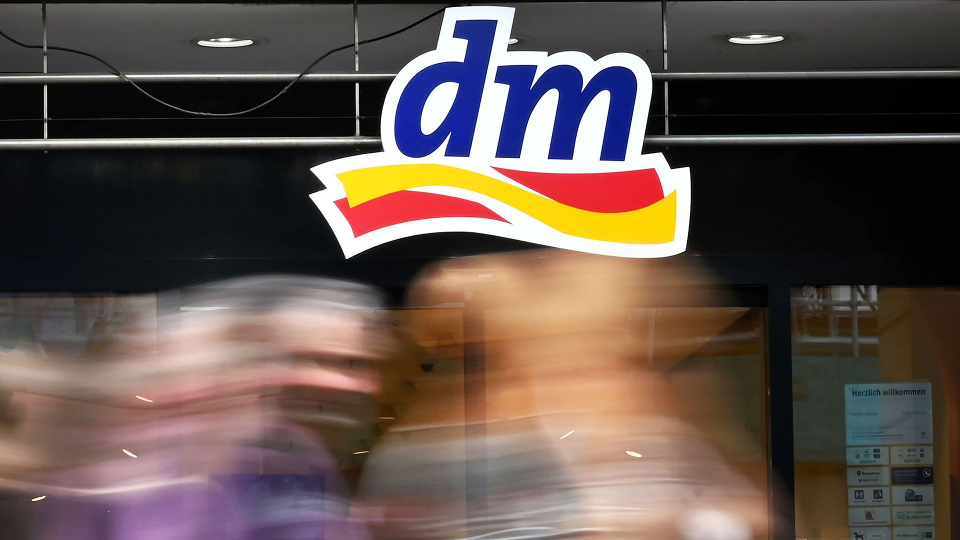 An der Fassade eines Geschäfts hängt das Logo von dm.