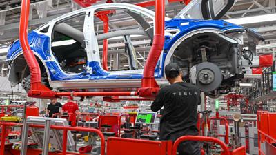 Ein Mitarbeiter der Tesla Gigafactory in Brandenburg. Der Autobauer hat dem Land ein starkes Wachstum beschert.