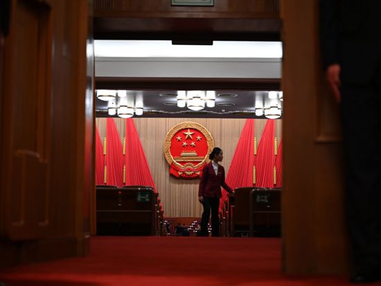 Eine Frau geht durch den Plenarsaal der Großen Halle des Volkes in Peking. Chinas Wirtschaft soll nach dem Willen der Regierung in diesem Jahr um „rund fünf Prozent“ wachsen.