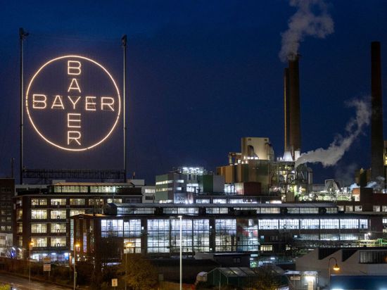 Das Logo des Unternehmens leuchtet auf dem Werksgelände in Leverkusen.