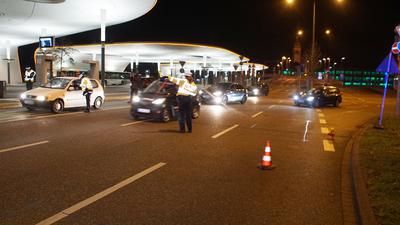 Polizisten halten am Pforzheimer Hauptbahnhof in der Nacht ein Auto an.