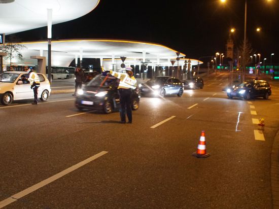 Polizisten halten am Pforzheimer Hauptbahnhof in der Nacht ein Auto an.