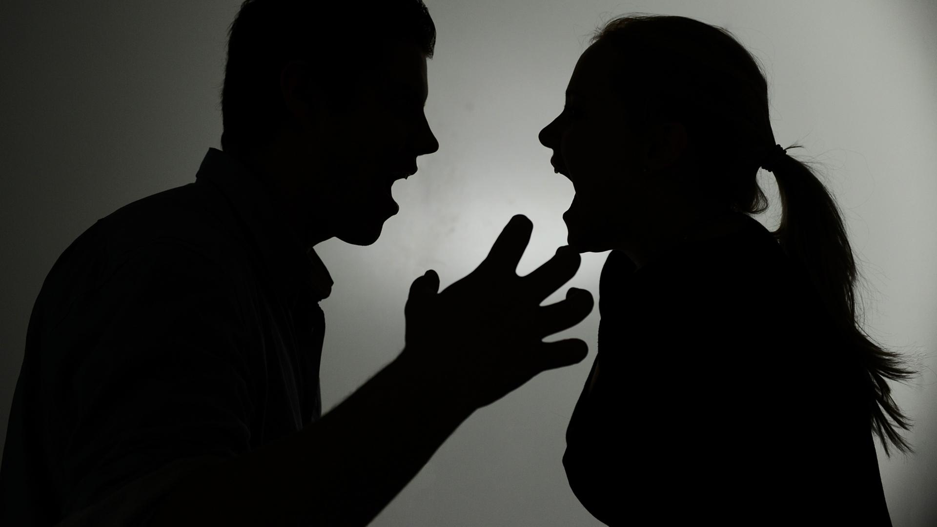 Ein als Silhouette abgebildeter Mann und eine Frau schreien sich gegenseitig an.