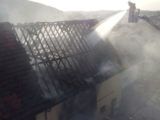 Die Feuerwehr löscht mithilfe einer Drehleiter den Brand eines Wohnhauses in Königsbach im Enzkreis.