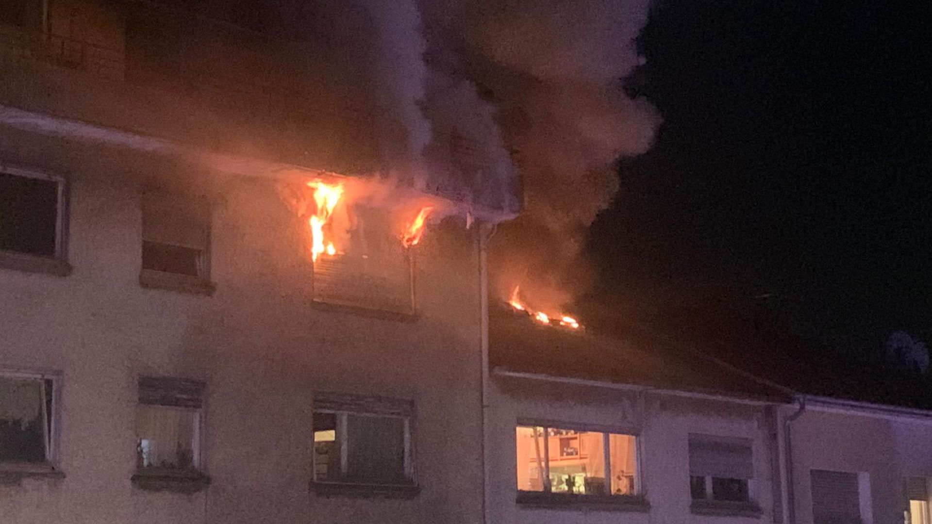 Flammen schlagen aus einem Fenster im Dachgeschoss eines Mehrfamilienhauses in der Anshelmstraße in Pforzheim.