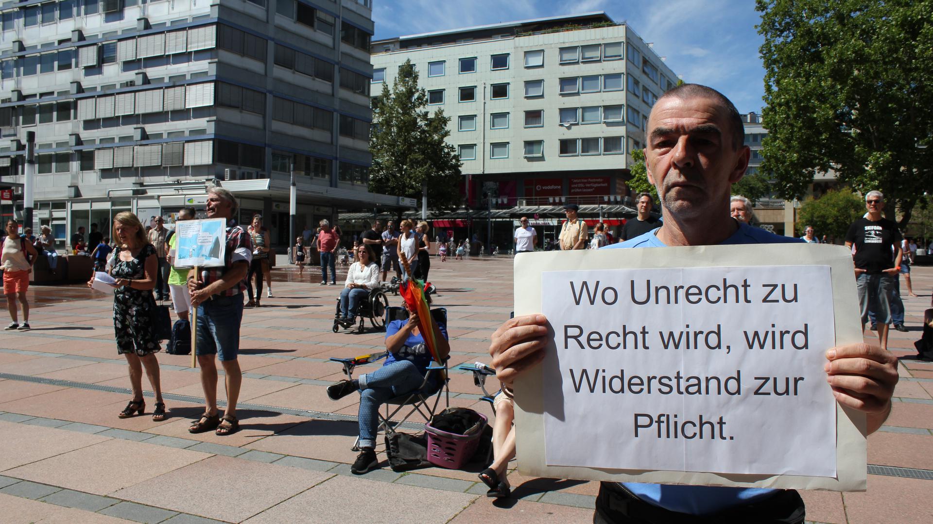 Demonstrant hält Schild bei Corona-Demo auf dem Pforzheimer Marktplatz.