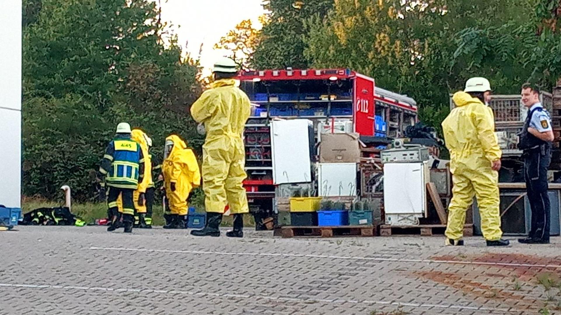 Ein Feuerwehrauto steht auf dem Betriebsgelände. Mehrere Feuerwehrleute in gelben Schutzanzügen sind vor Ort.