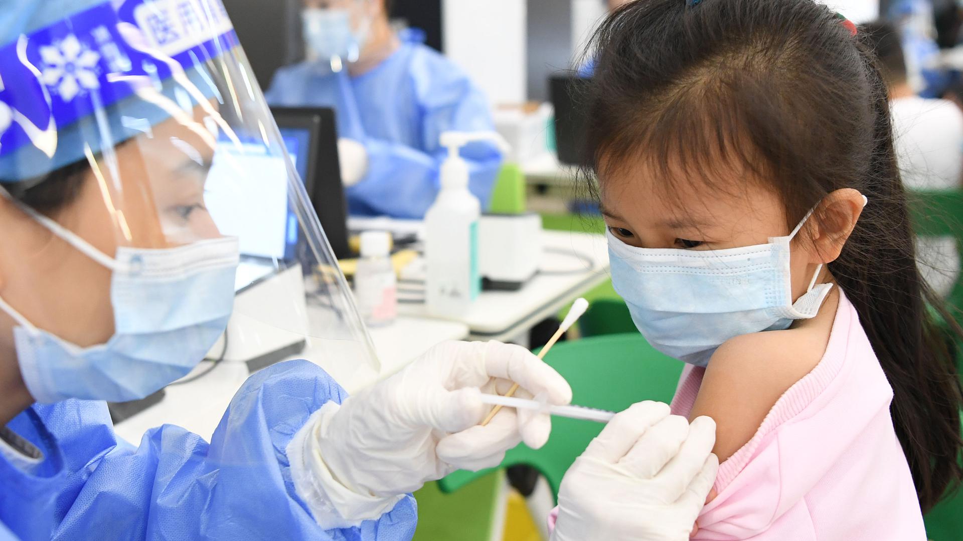 Ein medizinischer Mitarbeiter injiziert einer Schülerin in einer Grundschule eine Dosis eines Corona-Impfstoffs. Guangzhou hat mit der Corona-Impfung für Kinder im Alter von drei bis elf Jahren begonnen. Die EU-Arzneimittelbehörde entscheidet am Donnerstag über einen Impfstoff für Kinder ab 5 Jahre. +++ dpa-Bildfunk +++